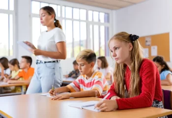 děti sedící v lavicích při výuce
