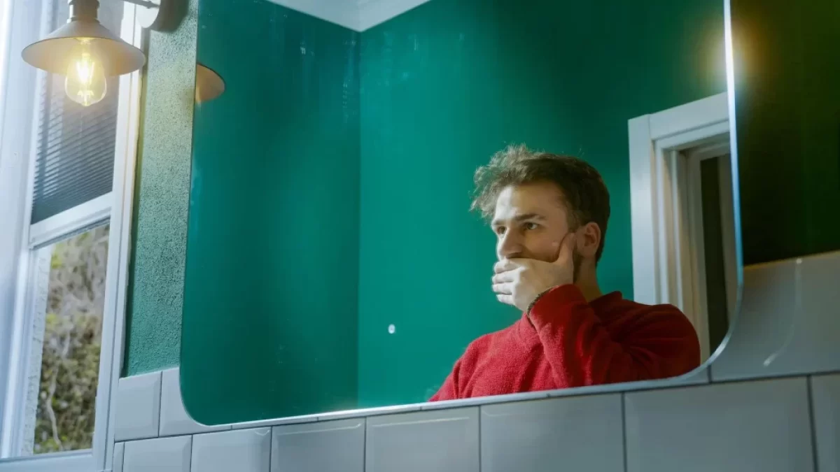 muž sleduje svůj odraz v zrcadle