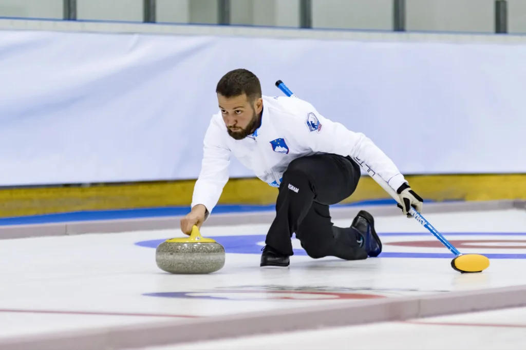 Mladý sportovec závodí na ledě v curlingu