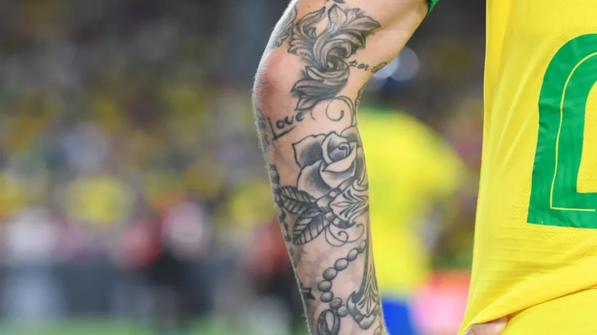 Detail ruky fotbalisty s tetováním.