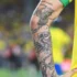 Detail ruky fotbalisty s tetováním.