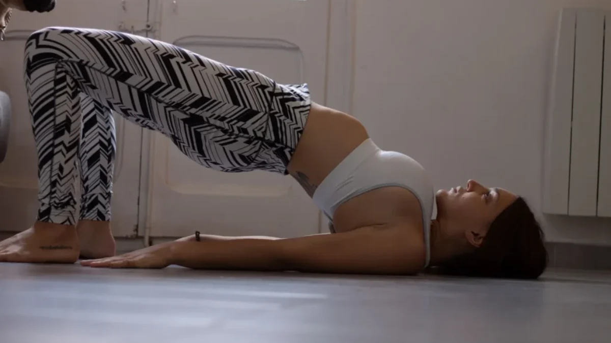 Žena cvičící doma glute bridge