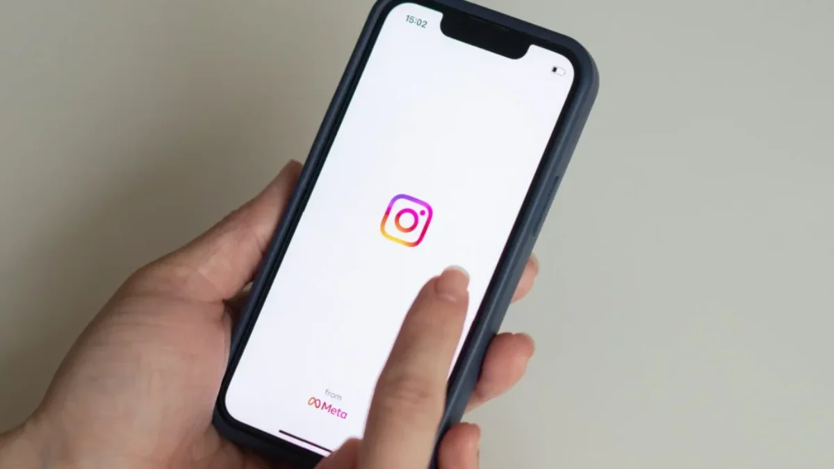 ženské ruce držící mobil s ikonou Instagramu na displeji