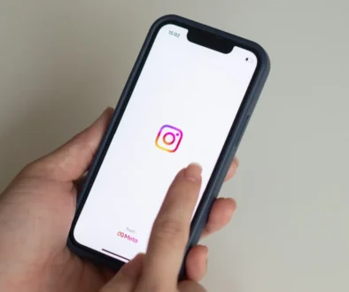 ženské ruce držící mobil s ikonou Instagramu na displeji