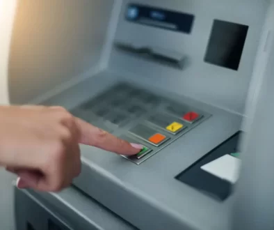 Ruka ženy mačkající tlačítka bankomatu