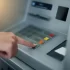 Ruka ženy mačkající tlačítka bankomatu