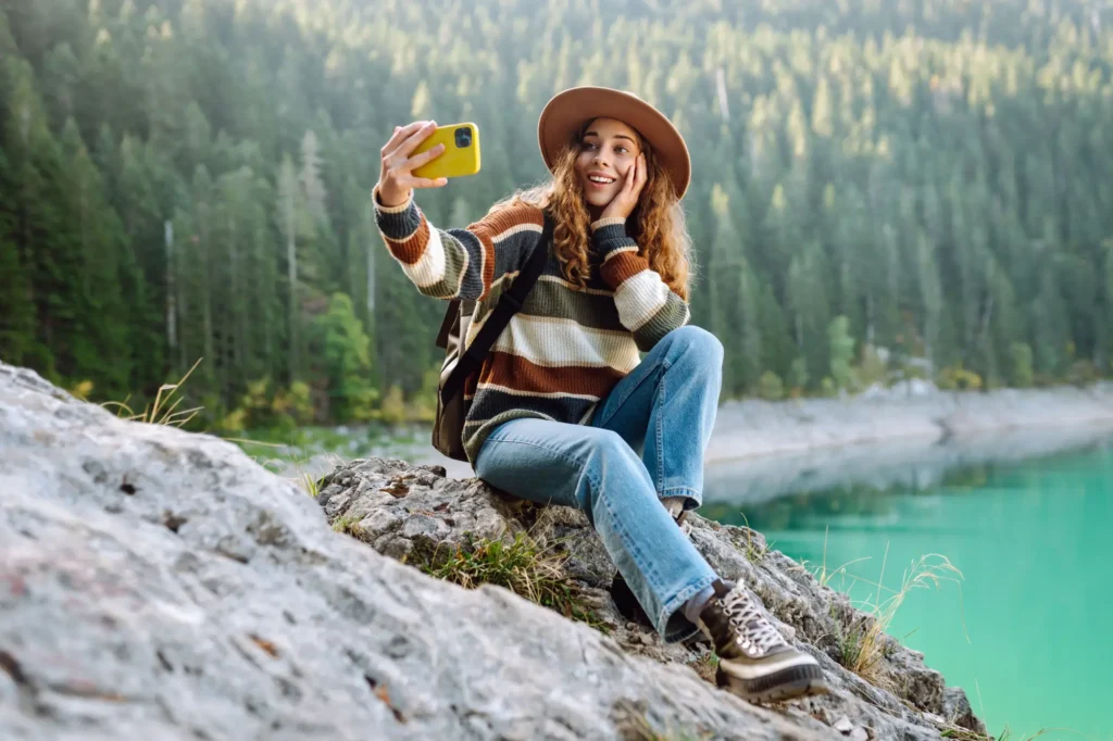 Mladá žena fotící si selfie u jezera