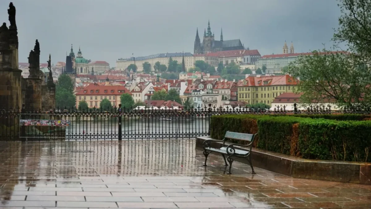Pražský hrad a město pod deštivou a zataženou oblohou.
