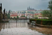 Pražský hrad a město pod deštivou a zataženou oblohou.