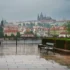 Pražský hrad a město pod deštivou a zataženou oblohou.