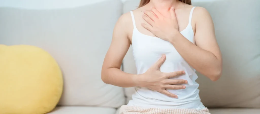 Žena provádí brániční dýchání s rukou na hrudníku a břiše.