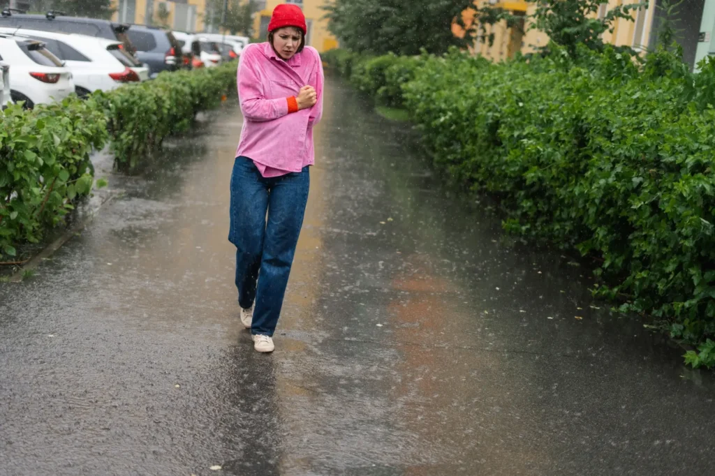 - SportDeník Žena kráčí ulicí během deště.