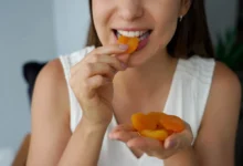 Mladá žena pojídající sušené meruňky