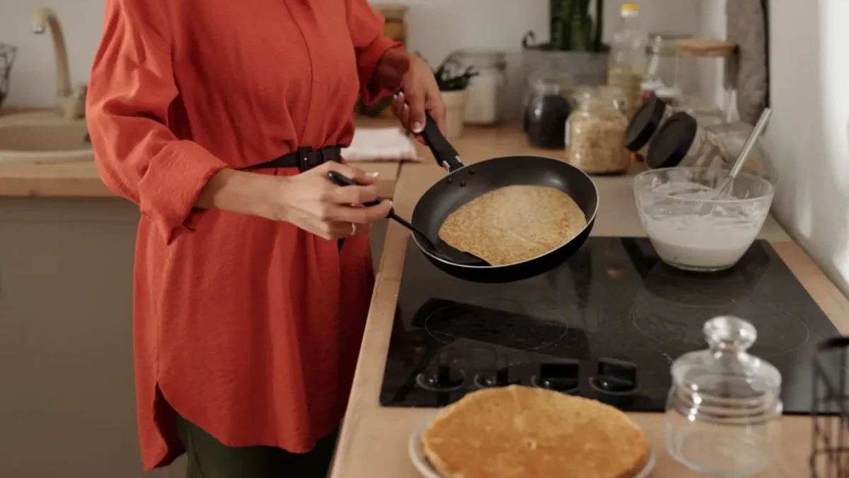 Žena u plotny smažící palačinky