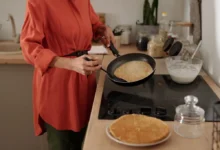 Žena u plotny smažící palačinky