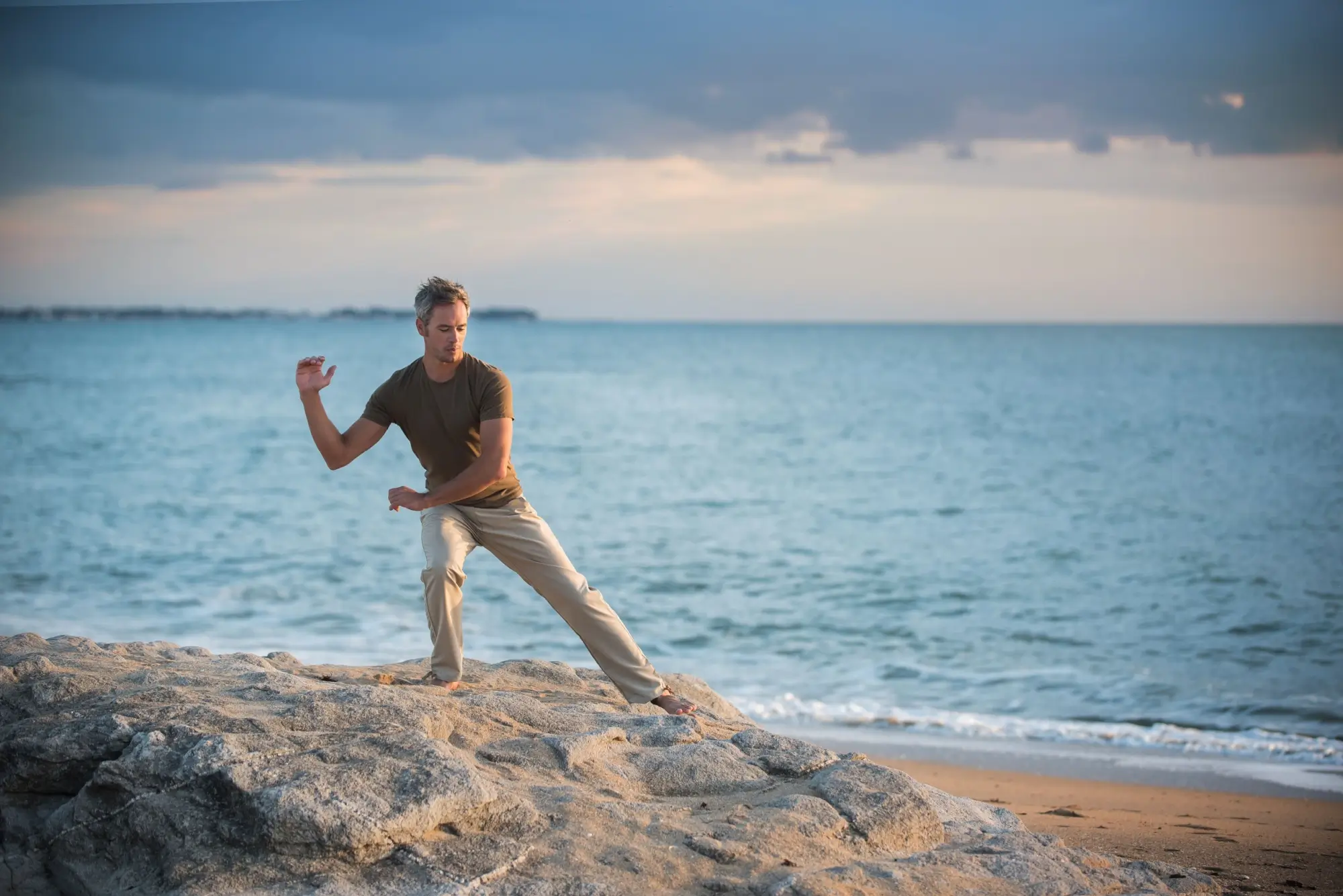 Shutterstock_638361610 - SportDeník Muž cvičí tai chi na mořském pobřeží