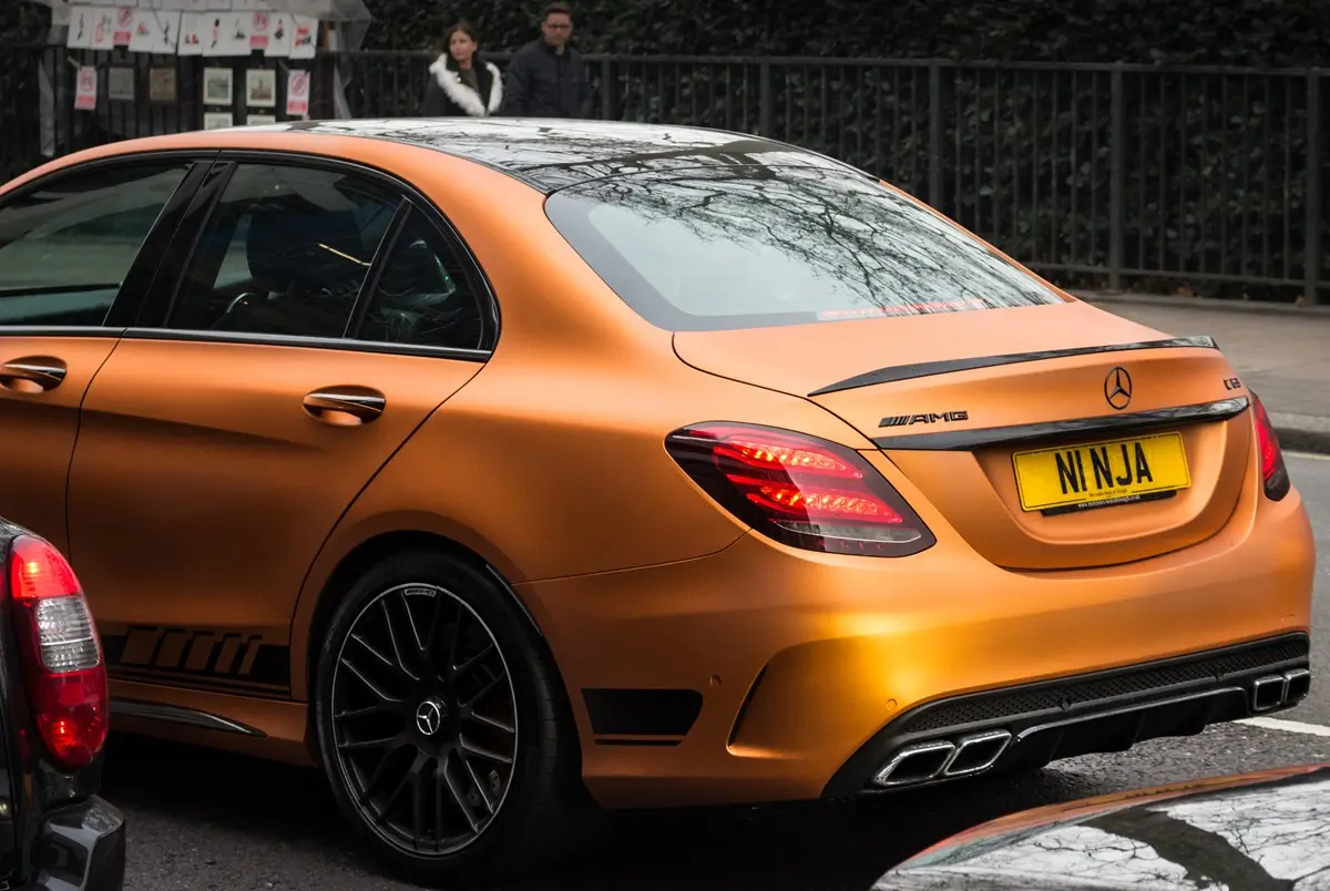 Oranžový Mercedes sportovního typu a na něm registrační značka na přání s nápisem Ninja