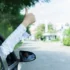 Záběr na přední část vozu, z kterého je vystrčená mužská ruka, ukazující palcem "jedničku"