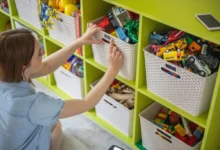 Učitelka v mateřské školce popisuje v šatně přihrádky dětem