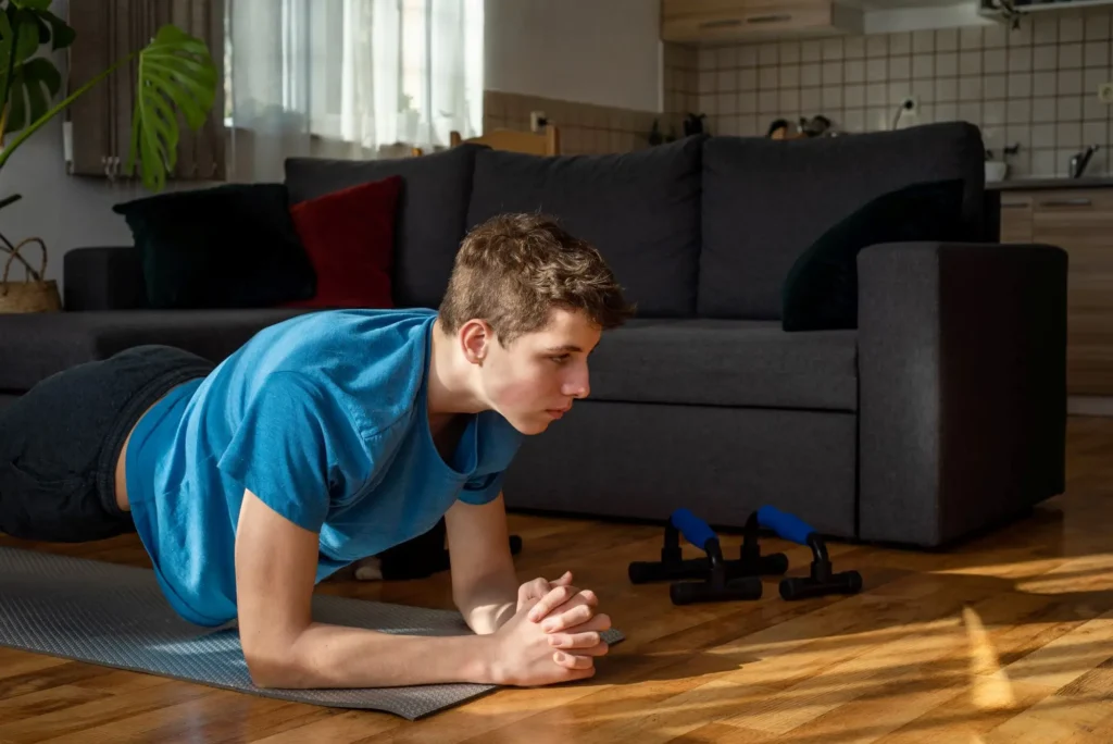 Plank zvládnete z pohodlí svého obývacího pokoje. - SportDeník muž v obývacím pokoji dělá plank