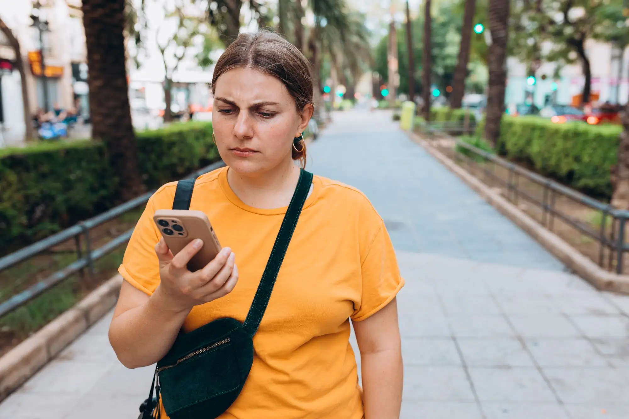 zamračená žena se dívá na displej telefonu