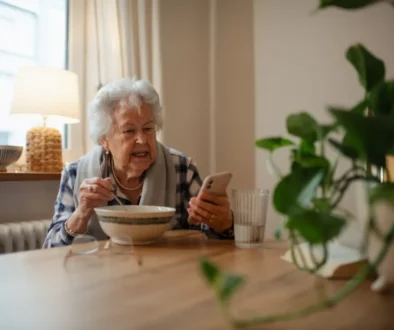 seniorka jí a dívá se na telefon