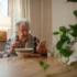 seniorka jí a dívá se na telefon
