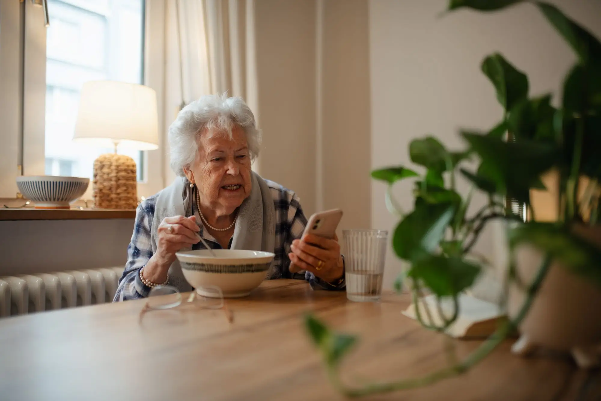 seniorka jí a dívá se na telefon