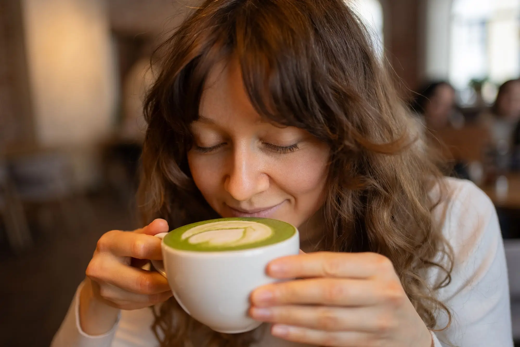 žena s hrnkem matcha latté