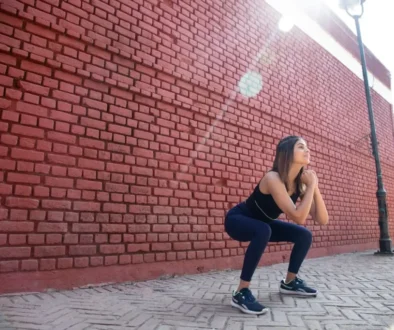 Mladá žena ve sportovním oděvu provádí hluboký dřep