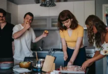 Čtveřice mladých lidí připravuje v kuchyni jídlo