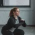 žena dřepuje v obyčejném oblečení