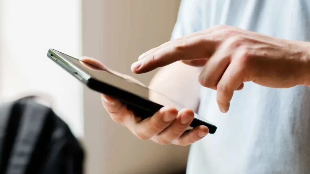 Ruce muže pracující na mobilu
