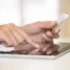 ženské ruce držící platební kartu a ťukající do tabletu