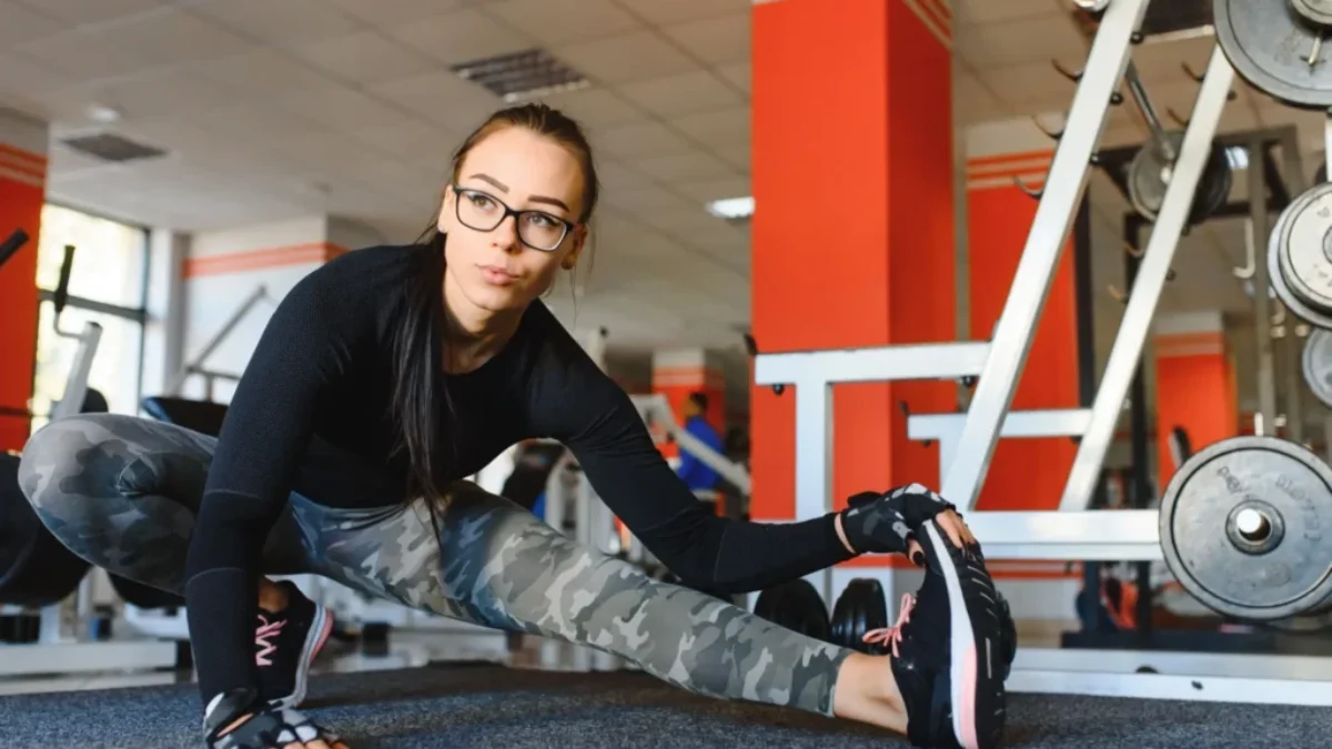 Žena protahující se v posilovně