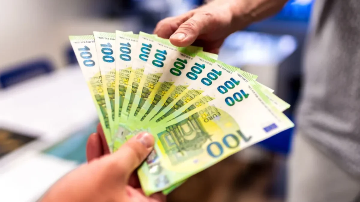 Dva muži si předávají euro bankovky