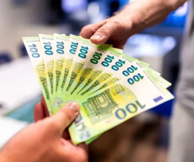 Dva muži si předávají euro bankovky