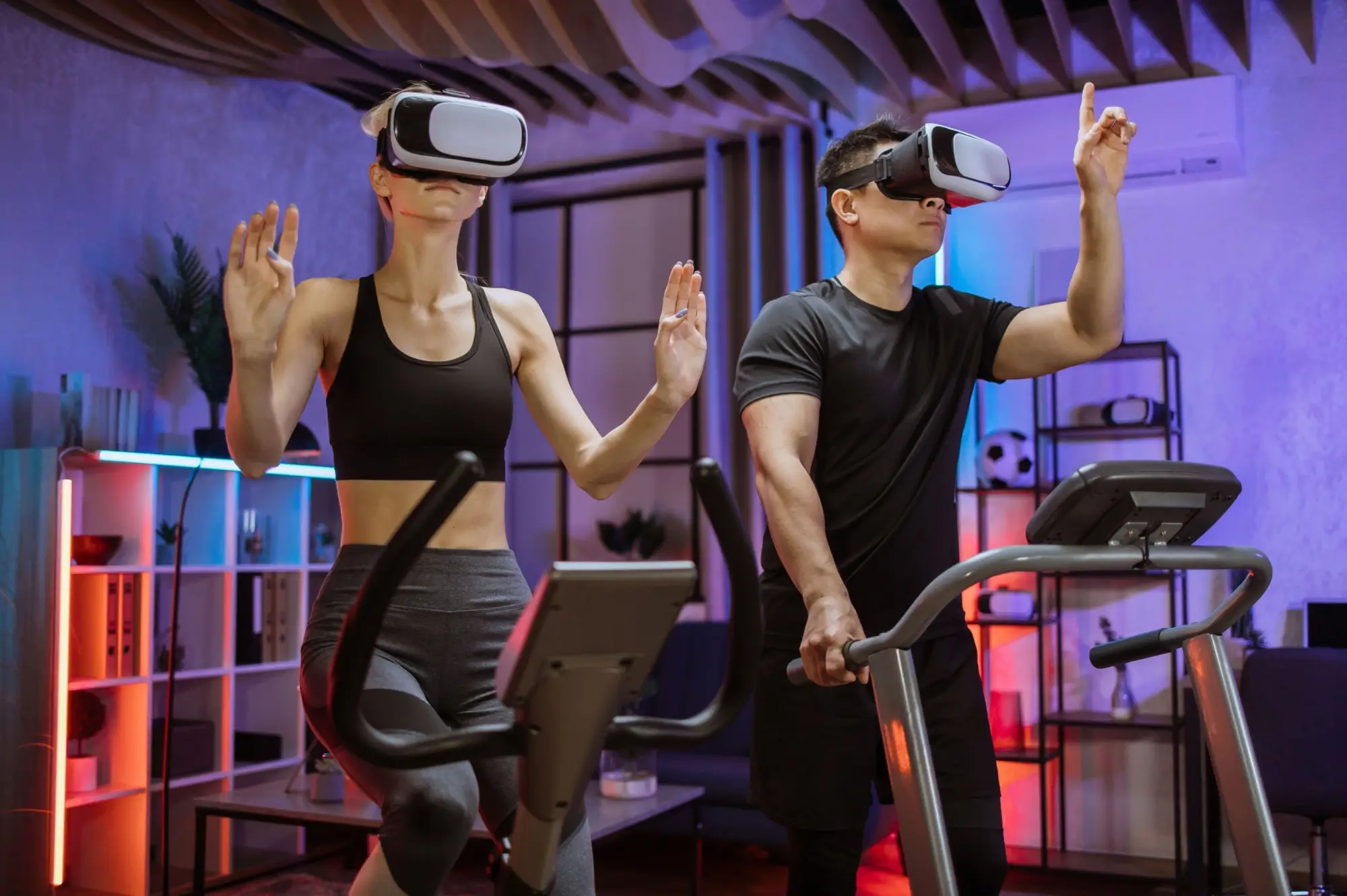 Muž a žena cvičí v posilovně s VR brýlemi