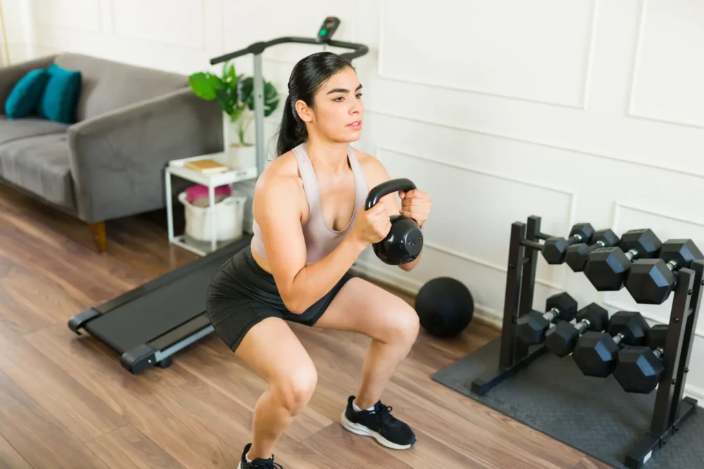 Shutterstock_2523559059 - SportDeník mladá žena cvičící dřep s kettlebellem