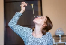Žena jí těstoviny.