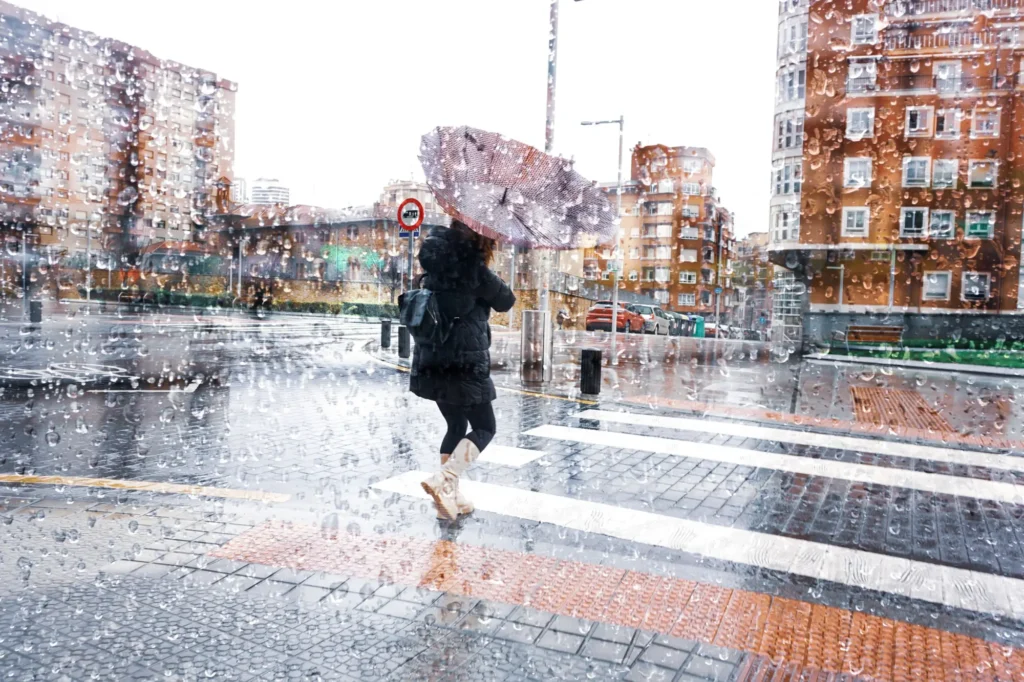 žena s deštníkem ve větru a dešti