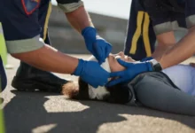 Záchranáři ošetřují zraněnou zenu ležící na silnici