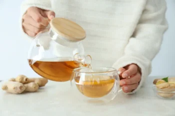 Člověk nalévá čaj do hrnku