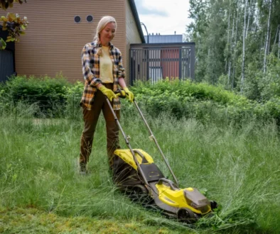 Žena seká trávu na zahradě