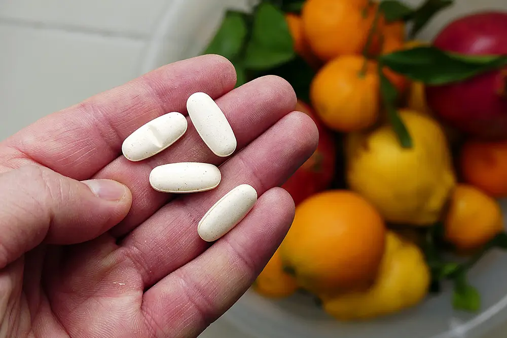 Každý vitamín má v těle člověka svou funkci. - SportDeník muž drží vitaíny