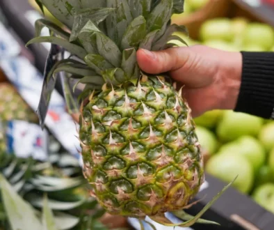 detail na ruku v supermarketu držící ananas