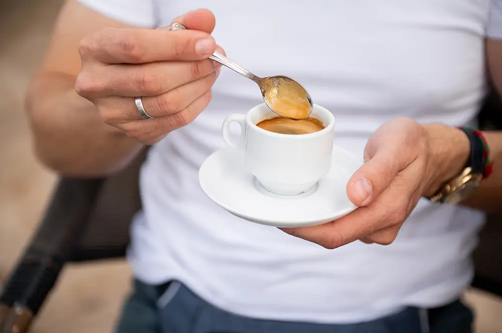 žena drží v ruce espresso