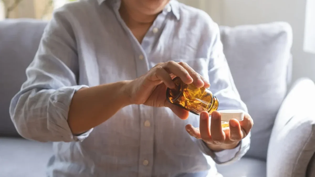 žena sy sype hrst vitamínů