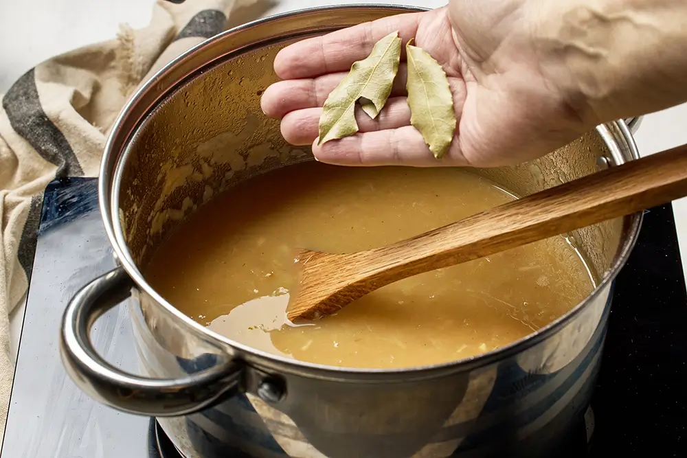 muž dává bobkový list do omáčky