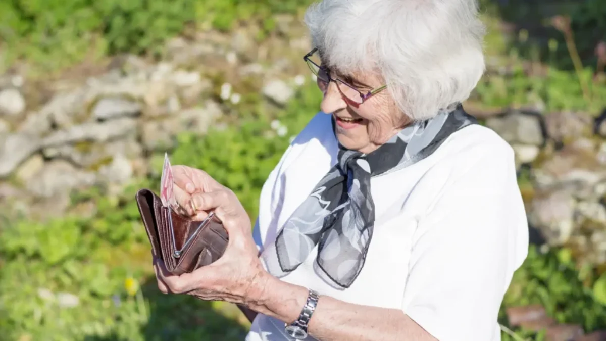 usměvavá seniorka s peněženkou